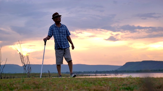 场景护士正在照顾年老的亚洲男性病人使用手杖和欣赏自然附近的湖，概念高级保健，护士正在照顾年老的病人视频素材