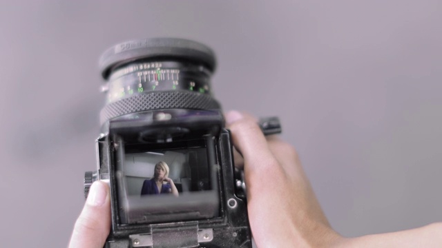 模特为摄影师摆姿势时对相机镜子的看法视频素材