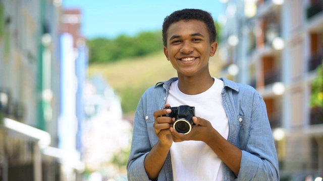 年轻的青少年带着相机在户外拍照和微笑，爱好和休息视频下载