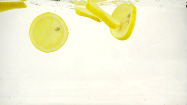 柠檬片掉进水里，慢镜头特写视频素材