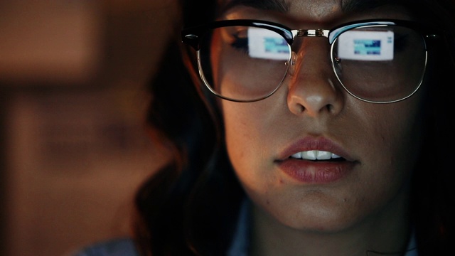 女人戴着一副眼镜，反射着笔记本电脑的屏幕视频素材
