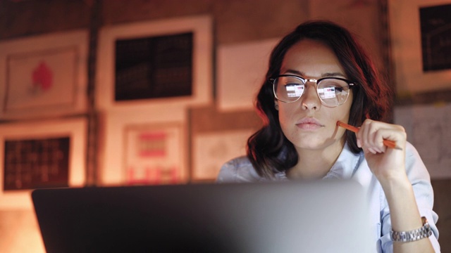 迷人的女人在笔记本电脑上工作到深夜视频下载