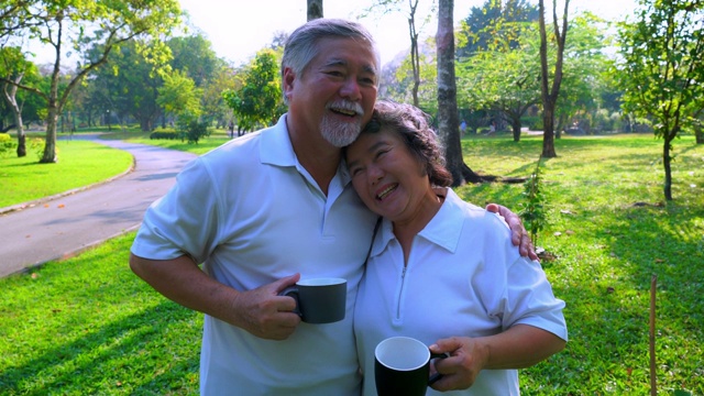 老人和老太太在公园里碰杯喝着美味的咖啡。爷爷亲吻奶奶的额头，老夫老妻是一对浪漫的夫妻。老夫妇幸福视频下载