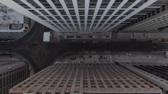 航拍:无人机在伊利诺伊州芝加哥市的高楼大厦间的高架铁路轨道上移动视频素材