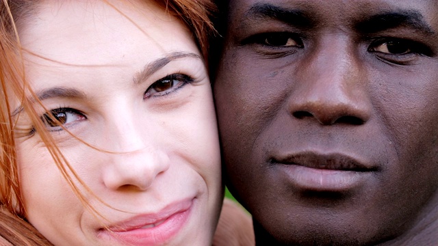 微笑迷人的白人妇女和黑人男子看着镜头。不同种族之间的爱视频下载