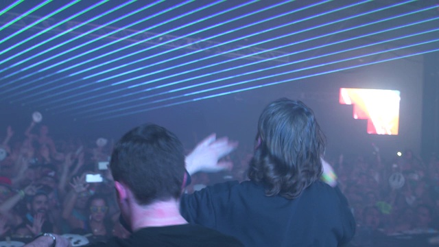 在纪念音乐节上，DJ让人们兴奋不已，激光在房间里射来射去视频素材