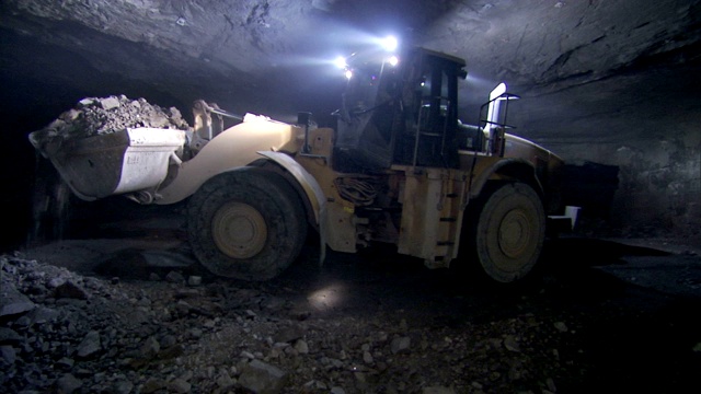 一种重型机械在隧道里搬运泥土。视频素材