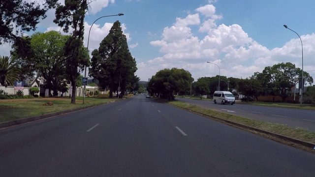 时间流逝:天空下的城市中，树木间街道上的车辆-约翰内斯堡，南非视频素材