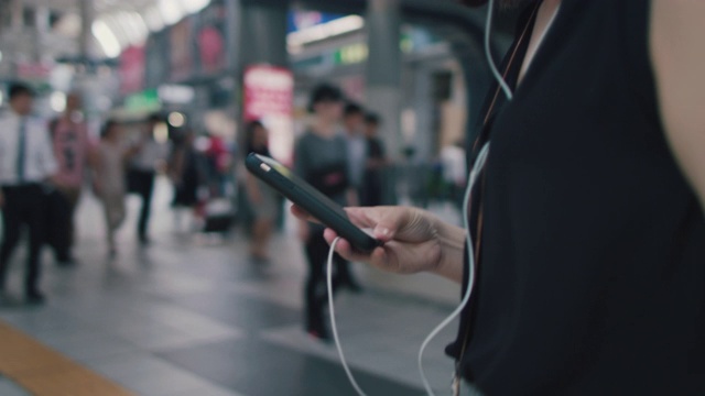 日本东京，一名日本女子拿着智能手机走路视频素材