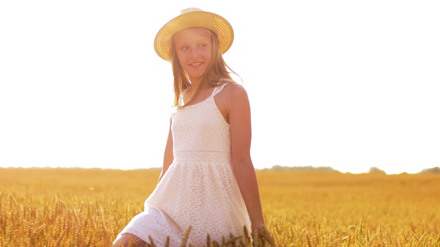 快乐的女孩戴着草帽走在麦田里视频下载