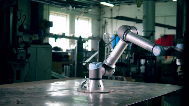 金属臂在工厂的桌子上工作。视频下载