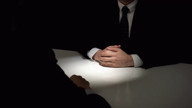在暗室里的秘密会议上，匿名的商业伙伴握手视频素材