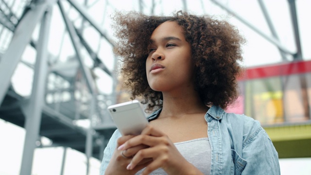 非裔美国青少年正在大街上使用现代智能手机视频素材
