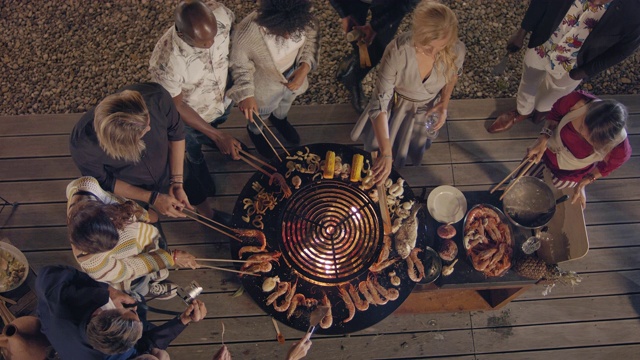 城市屋顶烧烤派对-温和的夏夜-顶部拍摄从起重机上面的人们一起braing视频素材