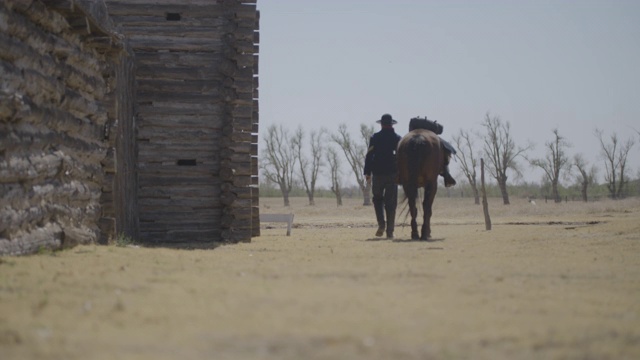 一个人牵着一匹马经过要塞视频素材