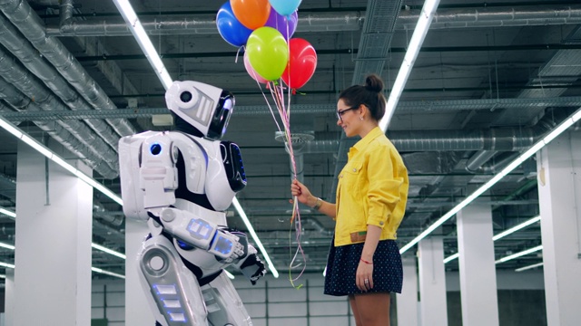 彩色气球由一个女孩送给一个机器人视频素材