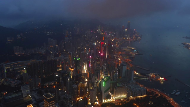 空中俯瞰香港市中心亚洲科技智慧城市的金融区和商业中心。摩天大楼和高层现代建筑在晚上的顶视图。视频素材
