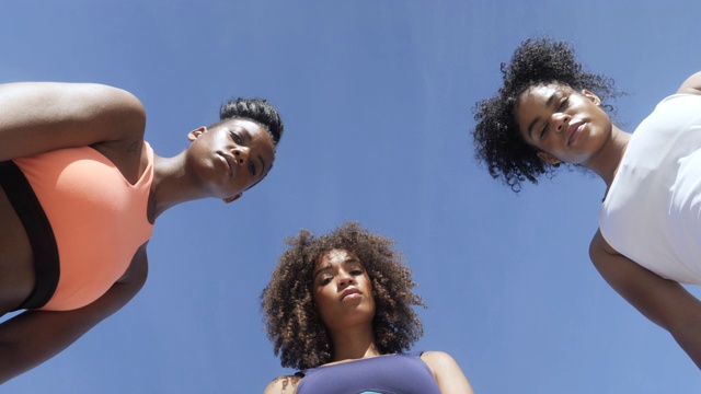 正下方，三位非裔美国女运动员对抗蓝天视频素材