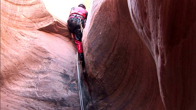攀岩者用绳子爬上光滑的岩壁。视频下载