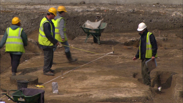 建筑工人在Tabard广场的一个挖掘地点周围测量。视频素材