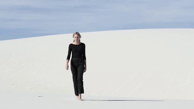 穿着黑衣的女人走在沙漠里，很宽视频素材