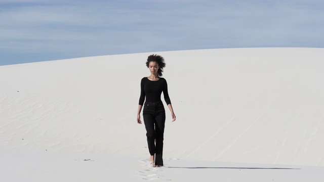 孤独的女人走在宽阔的沙漠里视频素材