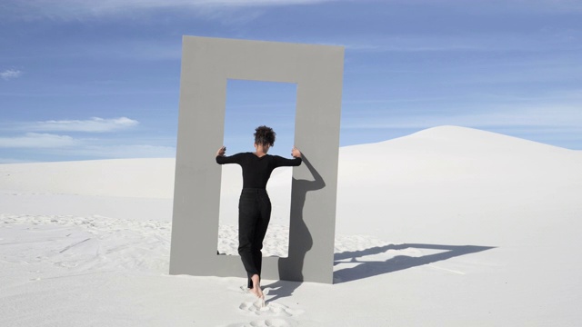 女人漫步在沙漠的门框里，宽阔视频素材