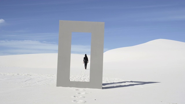 宽，女人从门框在沙漠视频素材