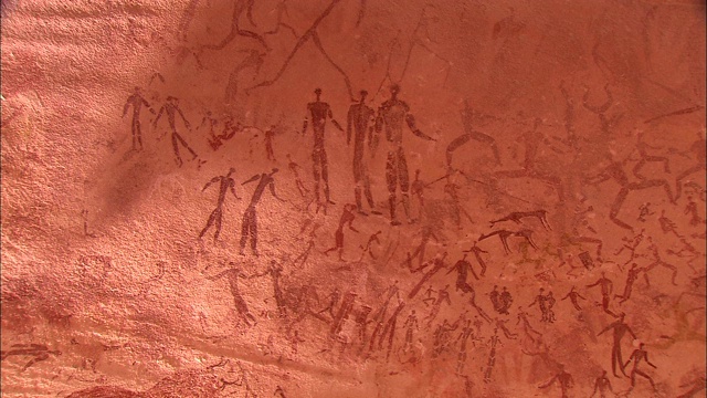 在撒哈拉沙漠的Gilf Kebir的悬崖上覆盖着人类和动物的岩画。视频素材
