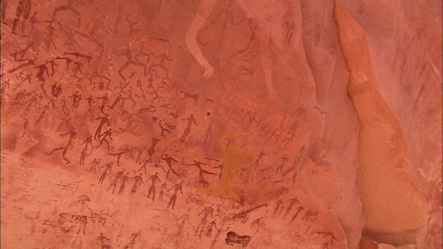 在撒哈拉沙漠的Gilf Kebir悬崖上，人们的岩画覆盖着。视频素材