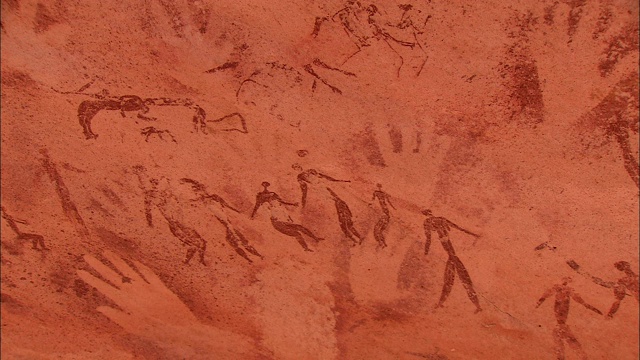 在撒哈拉沙漠的Gilf Kebir悬崖上，人们的岩画和手印覆盖着。视频下载