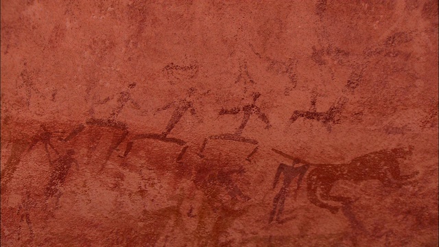 悬崖上的岩画描绘了人物和动物。视频素材