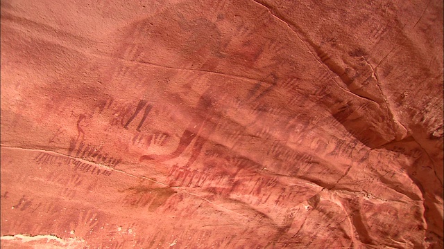 在撒哈拉沙漠的吉尔夫·凯比尔，手印岩画覆盖着一个岩面。视频下载
