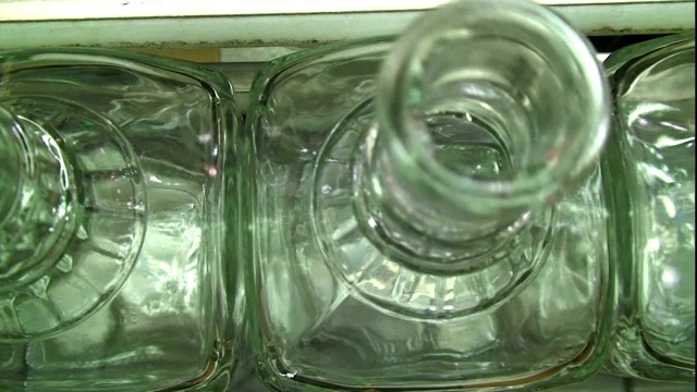 玻璃瓶沿着传送带移动。视频下载