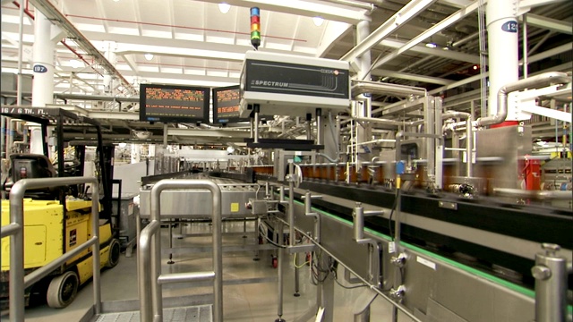 啤酒瓶在工厂的长传送带上旋转。视频素材