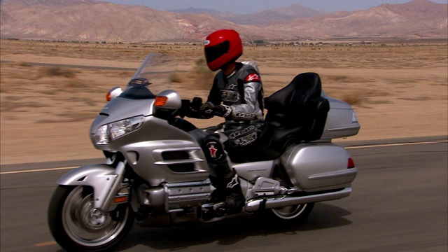 沙漠公路上银色的摩托车速度。视频素材