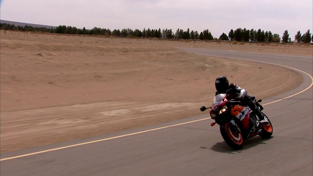 摩托车在弯弯曲曲的公路上倾斜。视频素材
