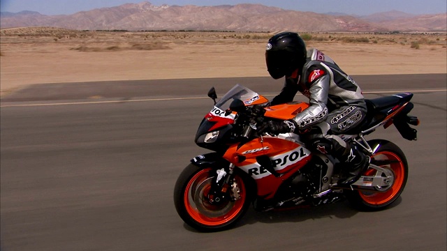摩托车在沙漠公路上飞驰。视频下载