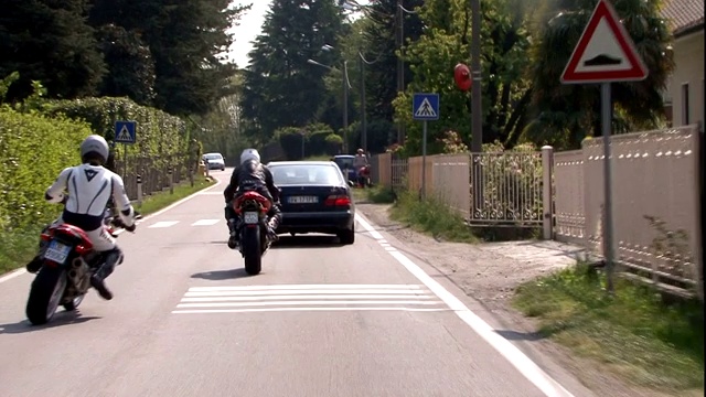 一个骑摩托车的人在住宅区里来回穿梭。视频素材