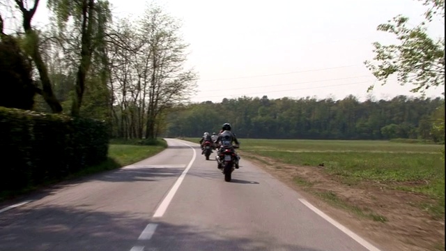 阿古斯塔摩托车在树木繁茂的道路上疾驰。视频素材