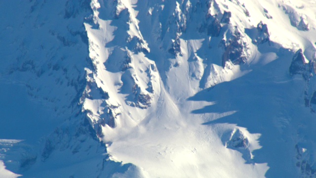 厚厚的积雪覆盖着崎岖的山腰。视频下载