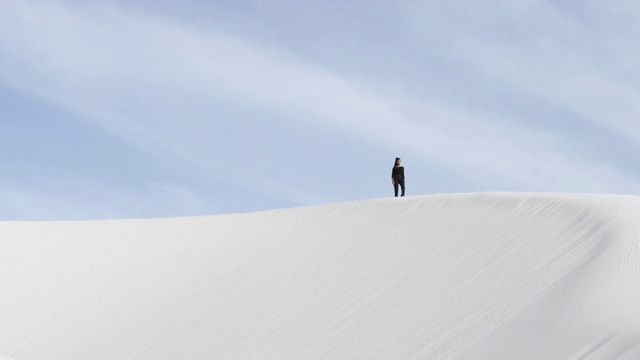 宽阔的沙漠，女人走过沙丘视频素材