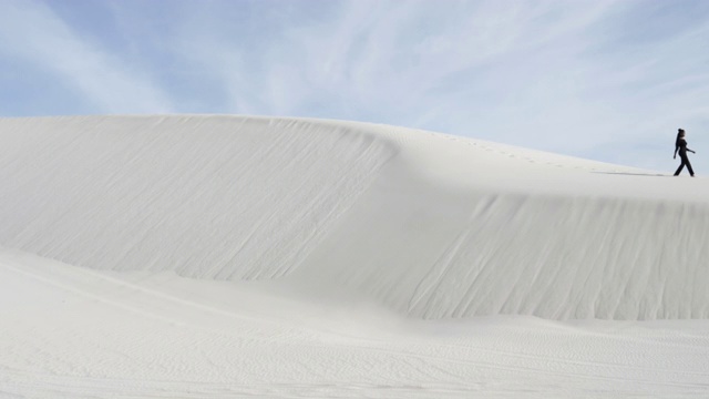 一个非裔美国女人走在宽阔的沙丘上视频下载