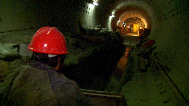 一个工人在一条长长的隧道里小心地开车。视频素材