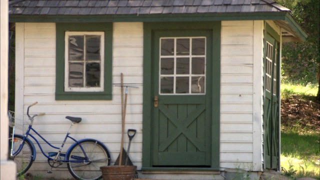 门廊的栏杆架着一间棚屋和一辆自行车。视频下载
