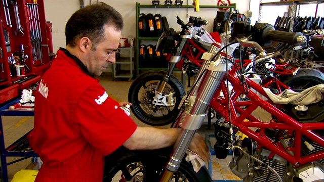 一名机械师在Bimota工厂打磨摩托车零件。视频下载