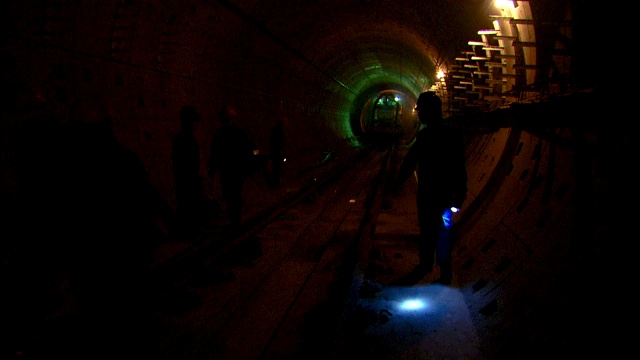 建筑工人在隧道施工现场远离轨道。视频素材