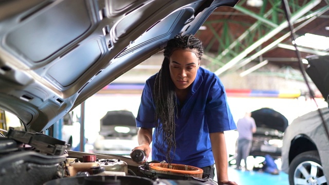 女人在汽车修理店修理汽车的肖像视频素材