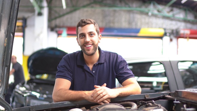一个男人在汽车修理店修理汽车的肖像视频下载