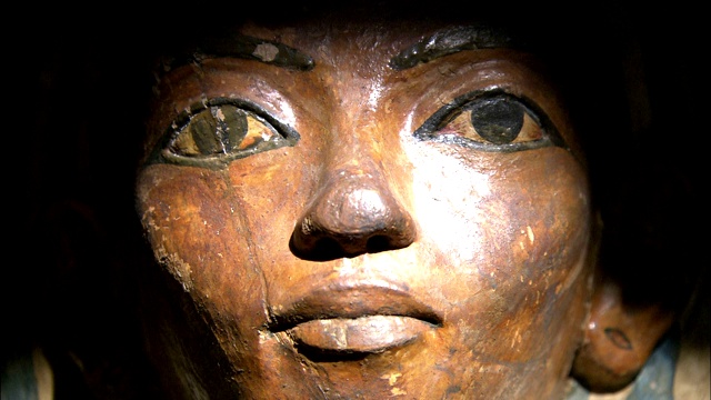灯光照亮了古埃及石棺上雕刻的人脸。视频下载
